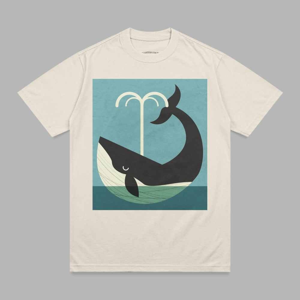 Cream t-shirt featuring a minimalist whale spouting water against a blue background.