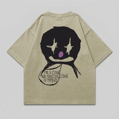 Tan t-shirt with black clown face graphic and text.
