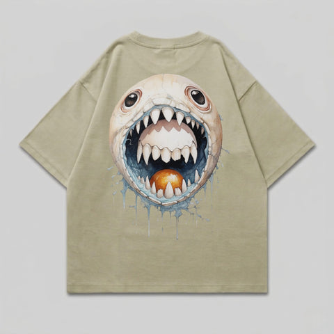 T-shirt with a cartoon monster face with an open mouth and orange ball.