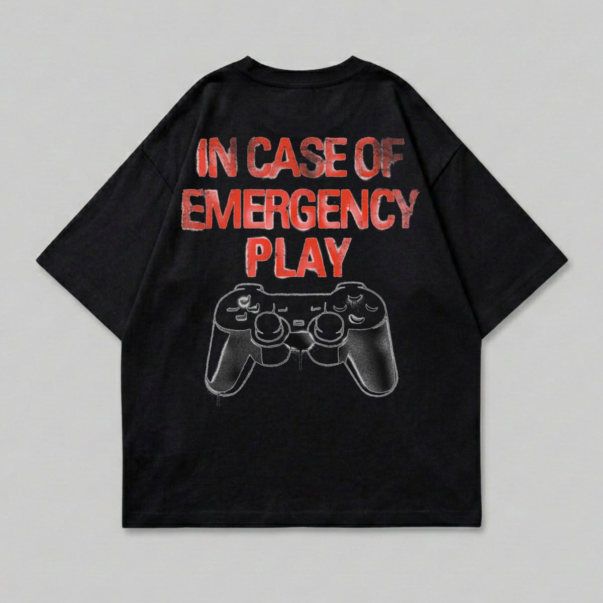 Black t-shirt with "IN CASE OF EMERGENCY PLAY" text and a video game controller graphic.