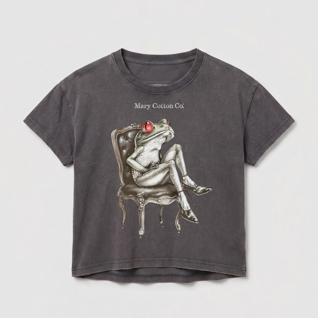 Graphic t-shirt featuring a stylized frog sitting on a chair.