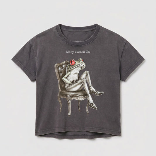 Graphic t-shirt featuring a stylized frog sitting on a chair.