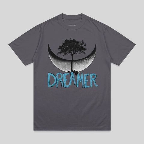 Dark grey t-shirt with a stylized crescent moon, tree, and "DREAMER" text.