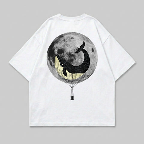 Whale in hot air balloon against full moon graphic on white t-shirt.