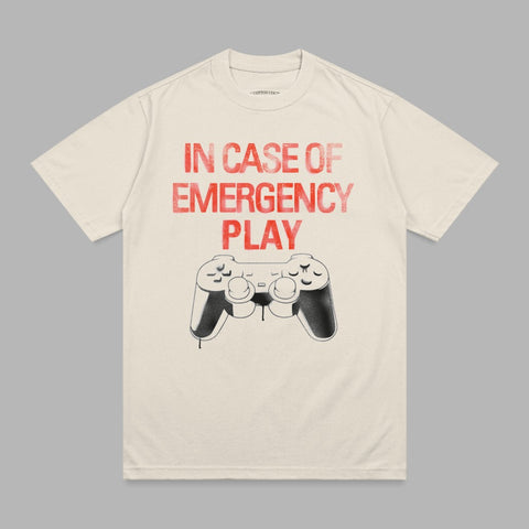 Cream t-shirt with red "IN CASE OF EMERGENCY PLAY" text and a video game controller.