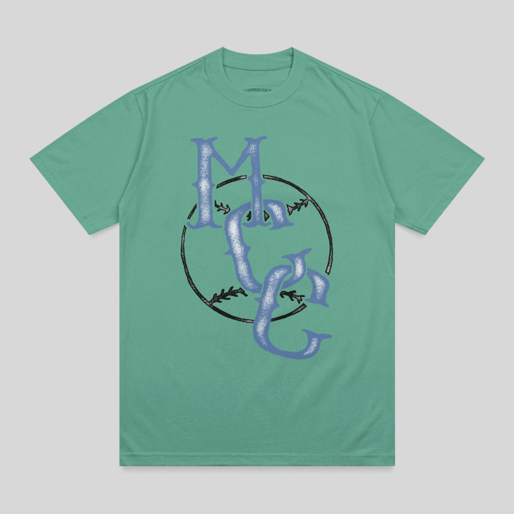 Green t-shirt with a large blue "MC" logo inside a black baseball circle.