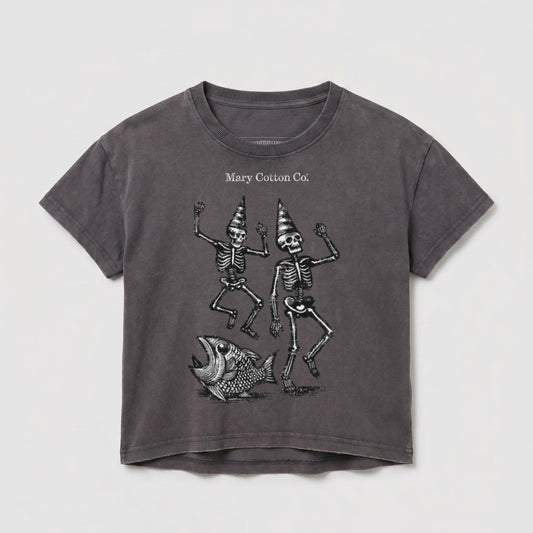 T-shirt with two dancing skeletons wearing party hats and a fish illustration.