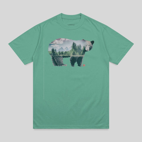 Bear silhouette filled with forest landscape and mountains.