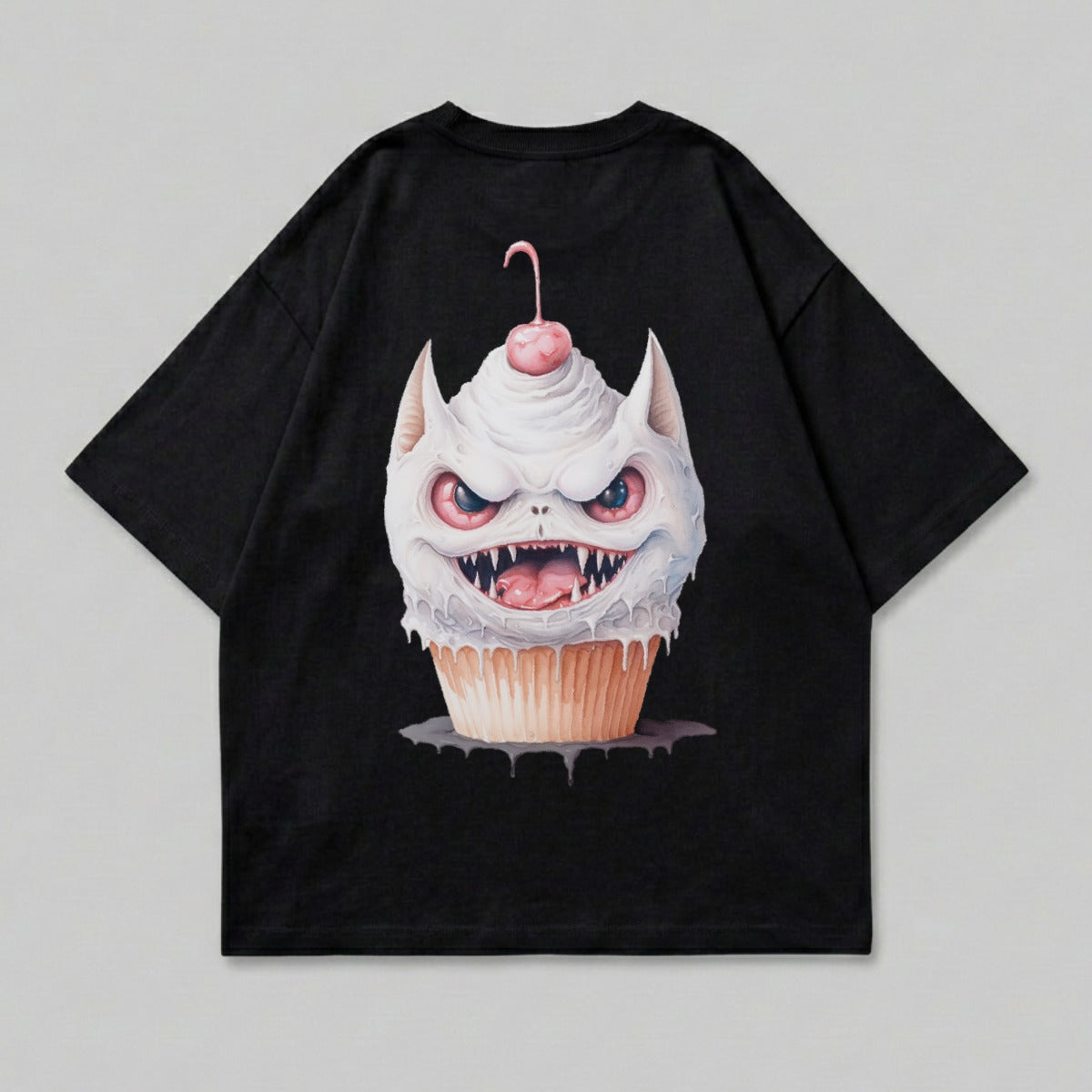 Black t-shirt with a monstrous cupcake design featuring sharp teeth and a cherry.