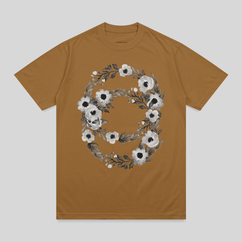 Brown t-shirt with a circular floral design in black and white.