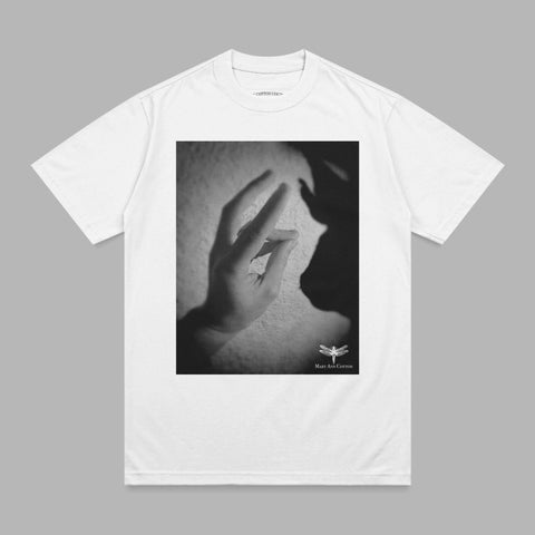 White t-shirt with black and white graphic of hands casting a shadow puppet.