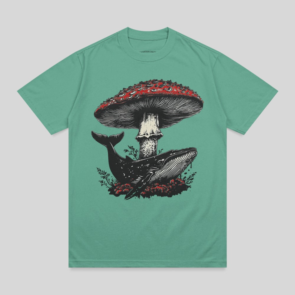 Whale and mushroom illustration on a teal t-shirt.