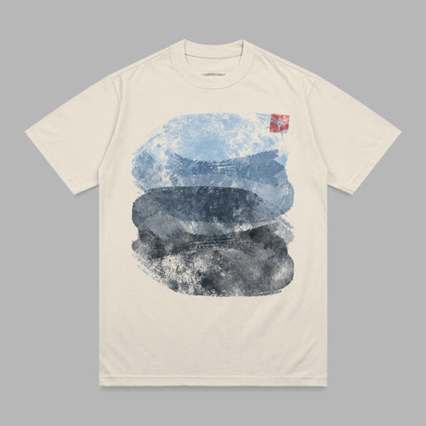 Cream t-shirt with abstract blue and gray watercolor brushstrokes.