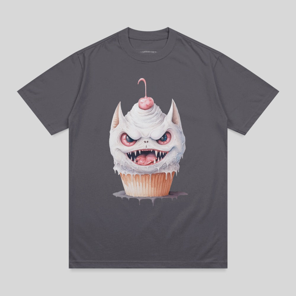 Illustration of a fanged cupcake monster with cherry on top, on a dark gray t-shirt.
