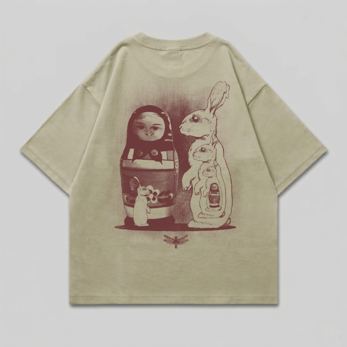 Matryoshka doll with rabbits and a dragonfly graphic on a light green t-shirt.