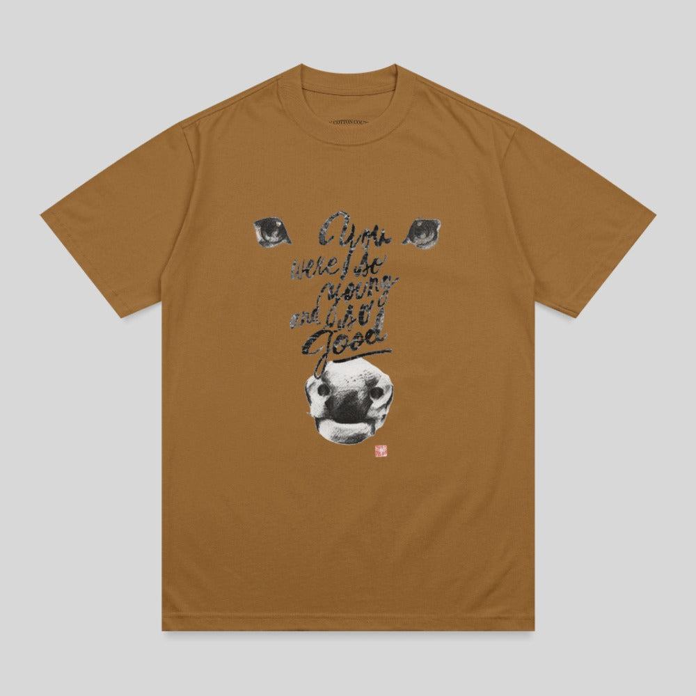 Brown t-shirt with graphic of a dog's face and text "I am here because I'm good".