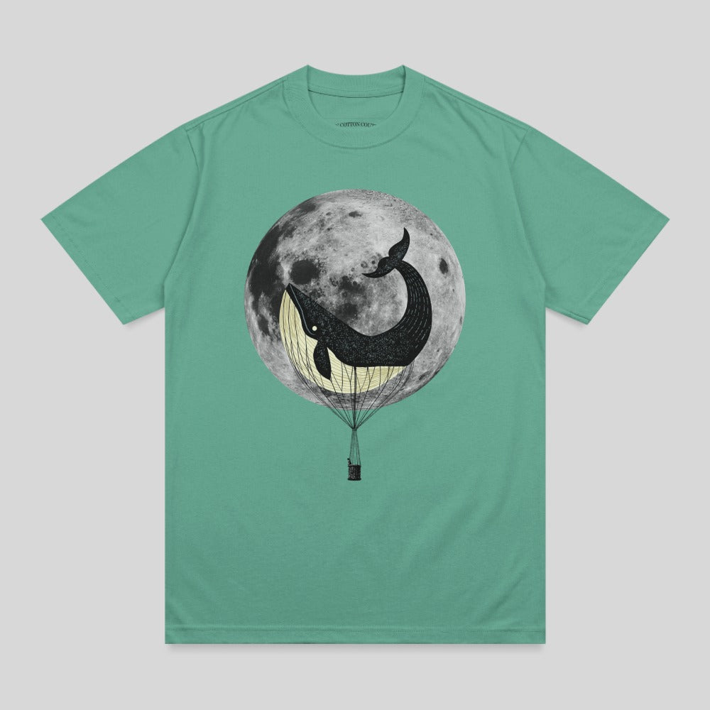Whale in hot air balloon against a full moon graphic on a t-shirt.