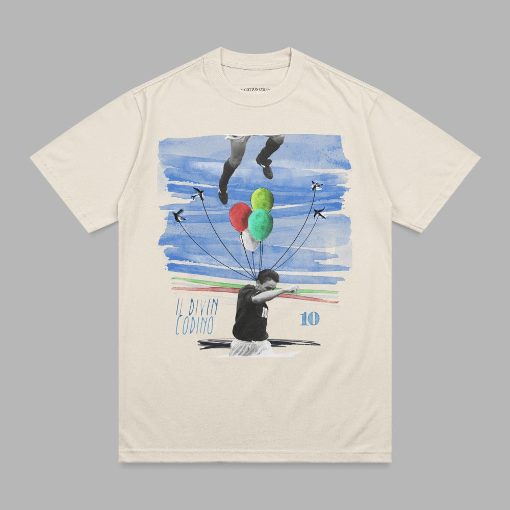 Cream t-shirt featuring a graphic of a soccer player with balloons and the text "IL DIVIN CODINO 10".