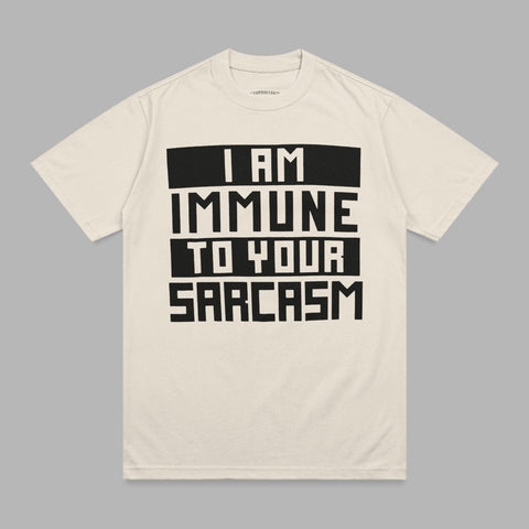Cream t-shirt with black text reading "I AM IMMUNE TO YOUR SARCASTIC".
