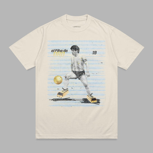 Cream t-shirt with Maradona kicking a soccer ball, "El Pihe de DAD" text.
