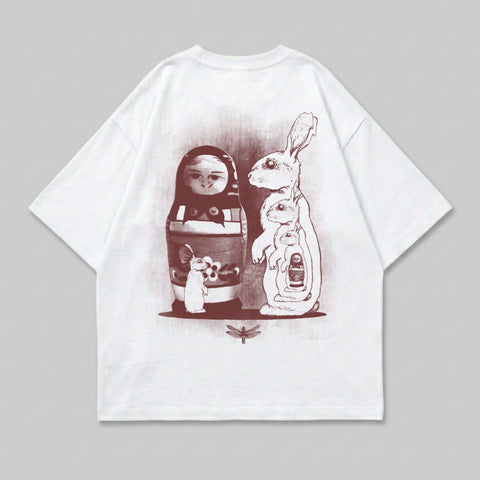 White t-shirt with matryoshka doll, rabbits, and dragonfly graphic.