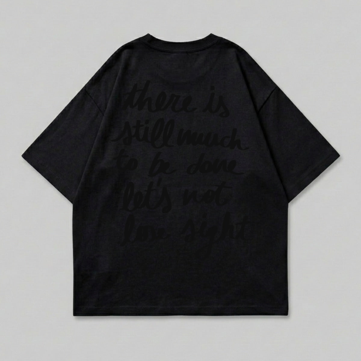 Black t-shirt with dark text reading "there is still much to be done let's not lose sight".