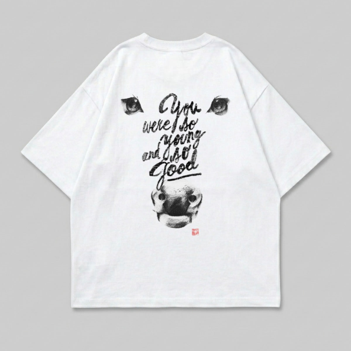 White t-shirt with a black ink drawing of a cow's head and text.
