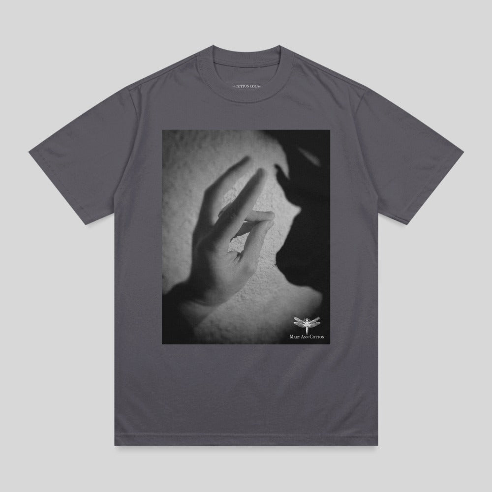 Shadow puppet of a rabbit on a t-shirt with a small dragonfly logo.