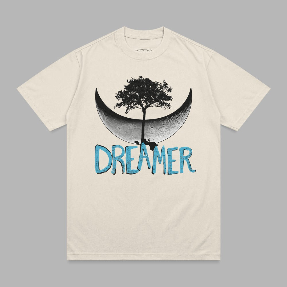 Cream t-shirt with crescent moon, tree, and "DREAMER" text graphic.