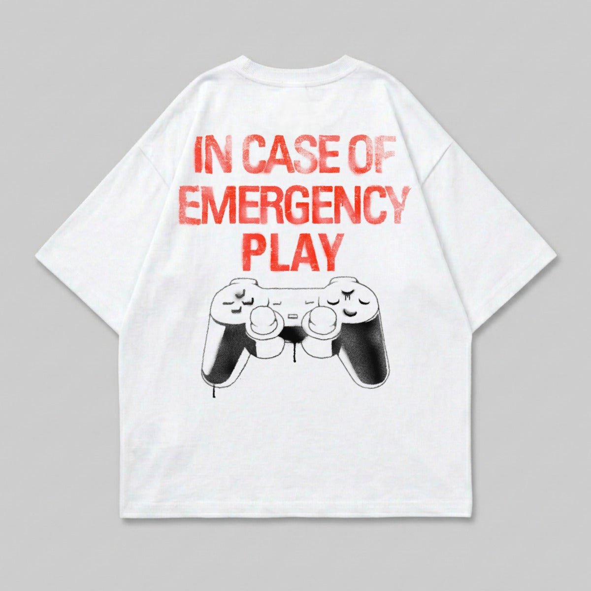 White t-shirt with red text "IN CASE OF EMERGENCY PLAY" and a video game controller graphic.