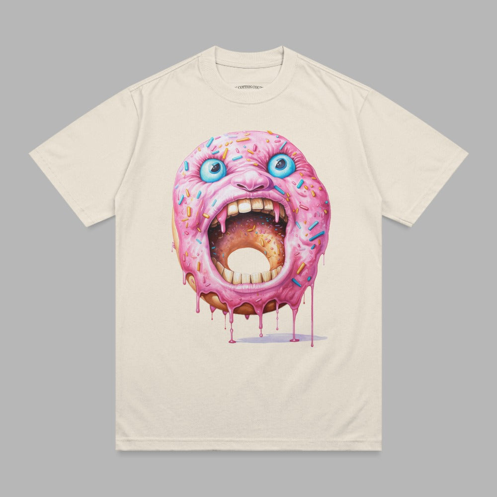 Cream t-shirt with a screaming pink frosted donut with blue sprinkles and red dripping icing.