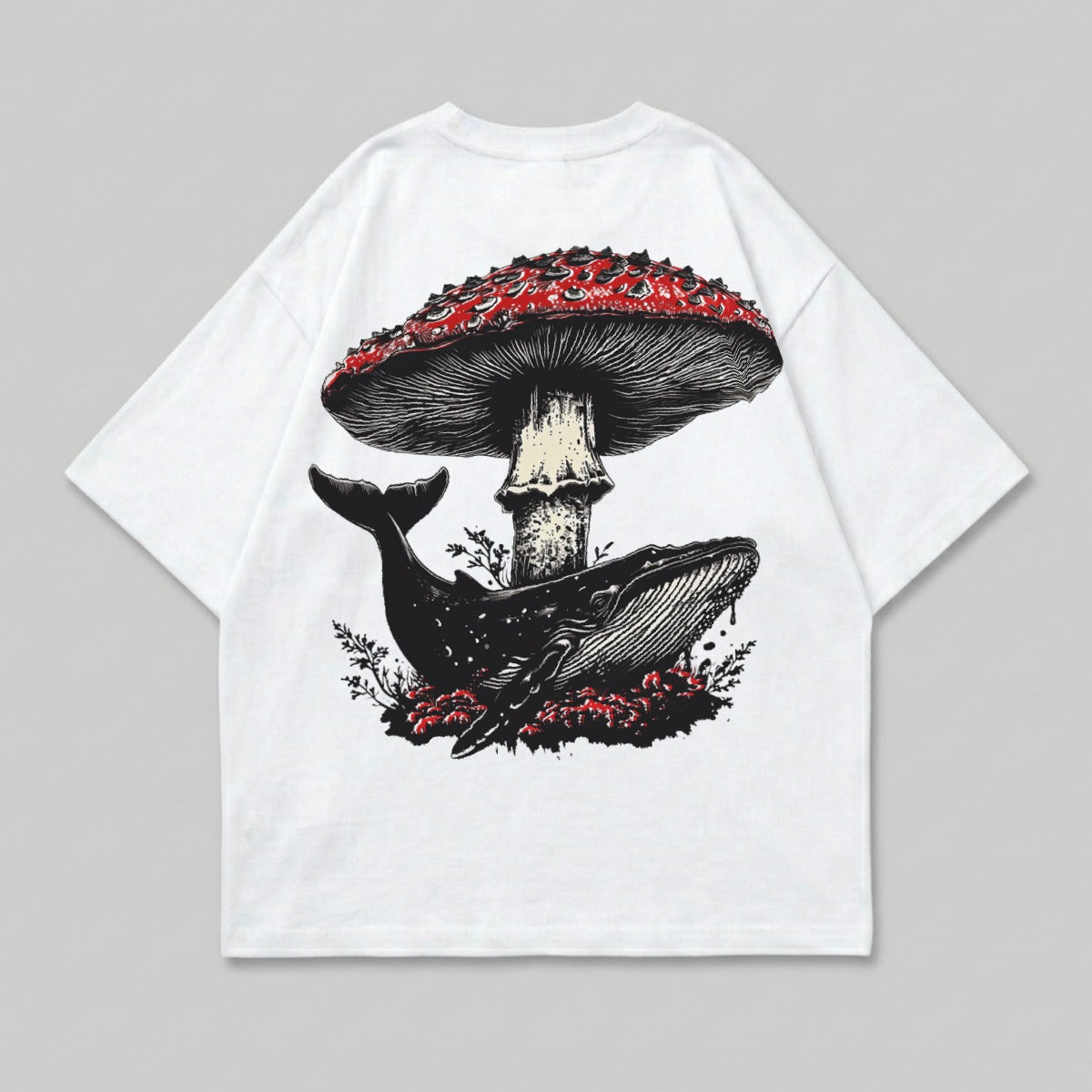 White t-shirt with a whale swimming under a large red mushroom.