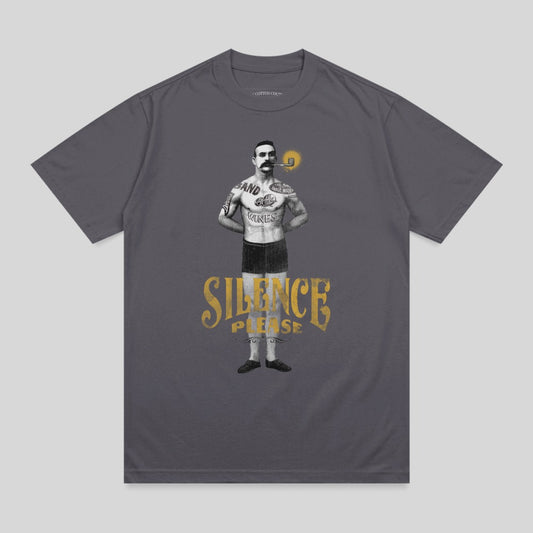 Man with cigar and tattoo wearing "Silence Please" shirt.