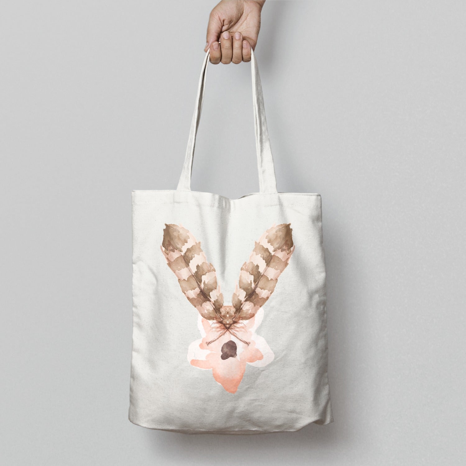 Hand Holding Tote Bag With Artistic Feather Design