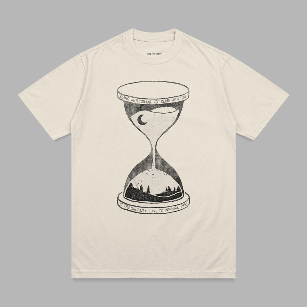 Cream t-shirt with hourglass illustration and text about time.