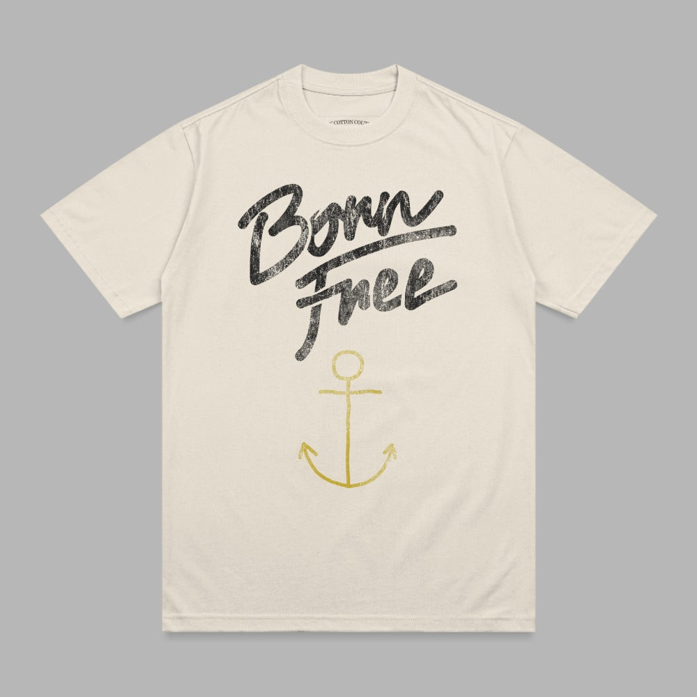 Beige t-shirt with "Born Free" in black script and a gold anchor.