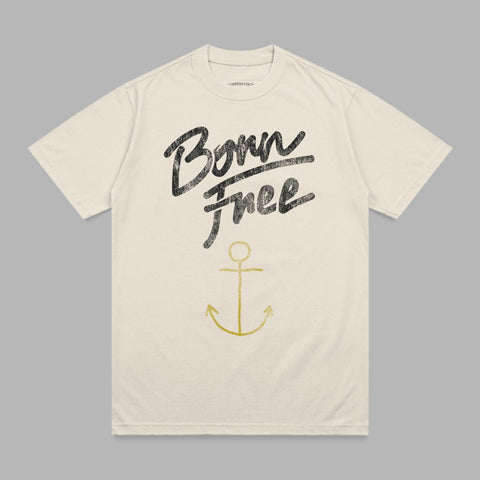 Beige t-shirt with "Born Free" in black script and a gold anchor.