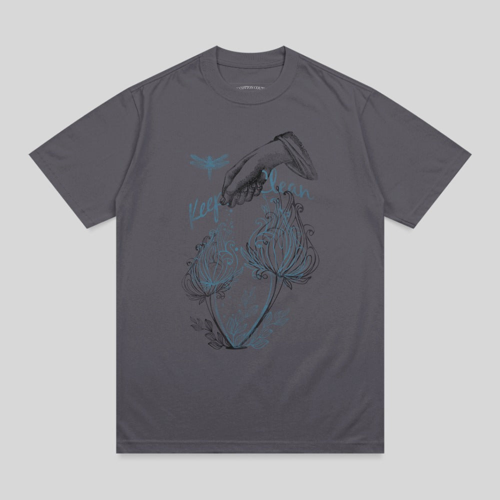 Dark grey t-shirt with illustration of hand, dragonflies, and glowing flowers.