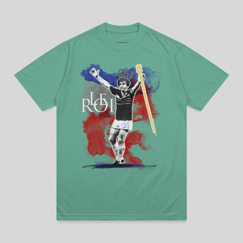 T-shirt graphic of soccer player with crown and scepter, "ROI" text.